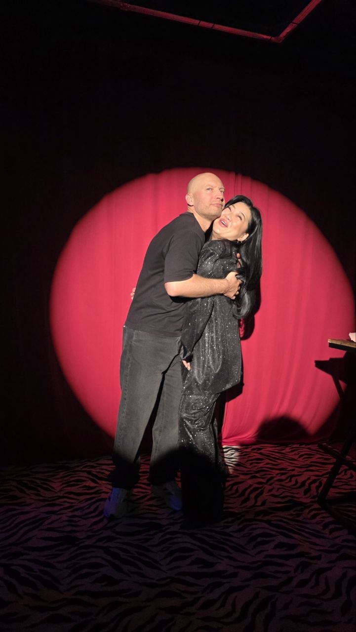 Артист и зрительница на фоне красного занавеса